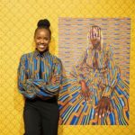 Thandiwe muriu debout à côté d'une de ses oeuvre